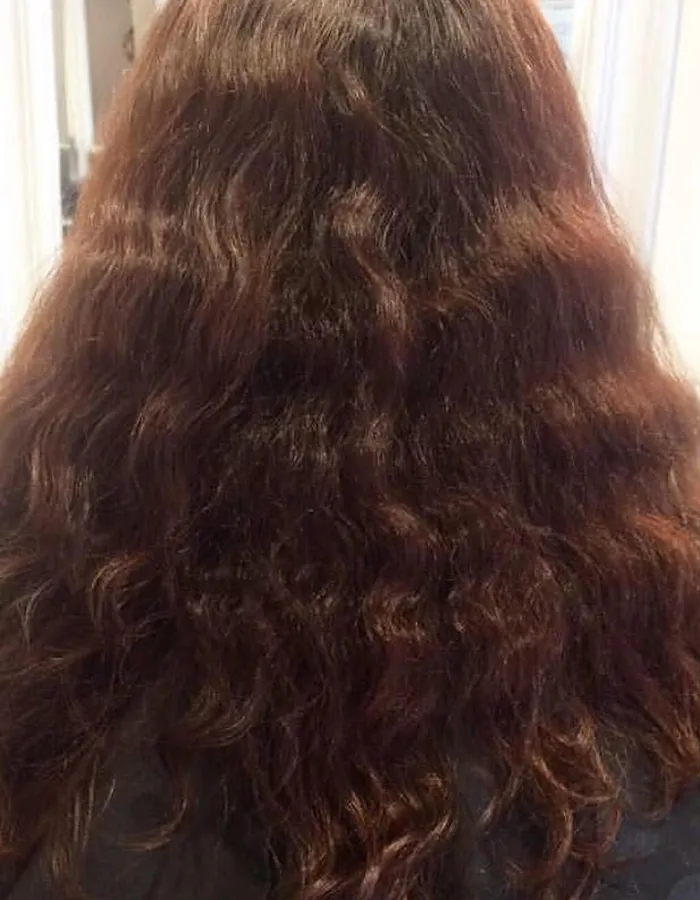 Wavy auburn hair before a smoothing treatment