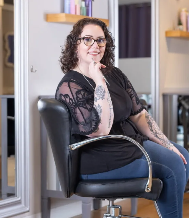 Amanda, stylist at Amy's Salon, seated in a styling chair