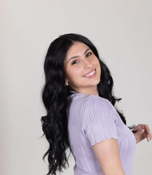 Eleni, stylist at Amy's Salon, with long dark wavy hair